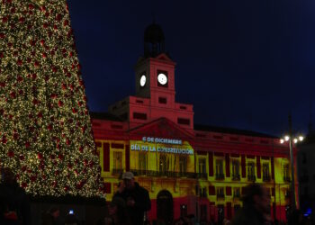La bandera de España se proyecta sobre la Real Casa de Correos con un videomapping para conmemorar el Día de la Constitución.